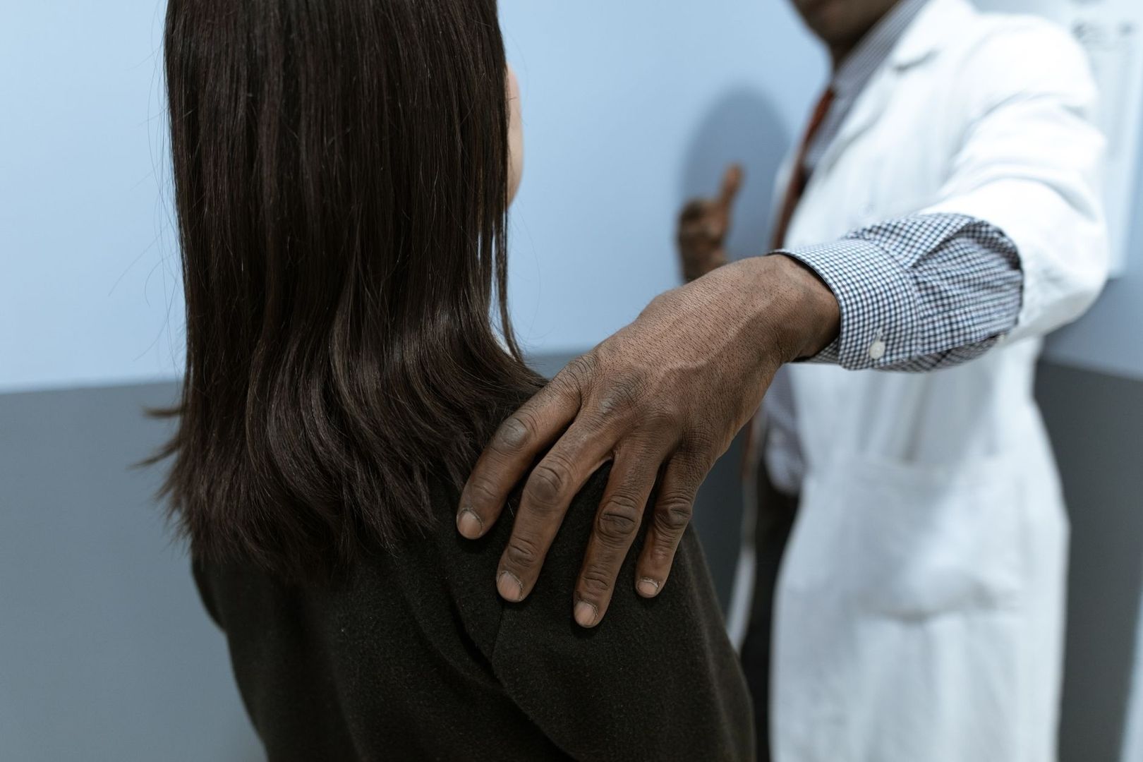 Vårdpersonal lägger handen på en patients axel under ett samtal